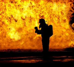 Feuerwehrmann vor Feuerwand im Einsatz Symbolbild der blaulichtSMS die Zusatzalarmierung via Alarm App für Feuerwehr Rettung THW Bergwacht und Co
